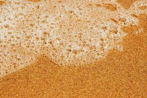 waterschuim met glad zand. horizontaal beeld. foto