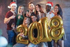 het nieuwe jaar van 2018 komt eraan. groepsportret van vrolijke oude vrienden communiceren met elkaar. het feest staat in het teken van de viering van het nieuwe jaar. concepten over jeugd saamhorigheid levensstijl foto