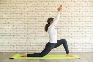 latijnse vrouw die yoga beoefent op mat foto