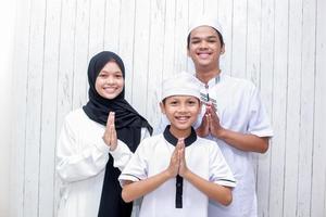 jonge moslimfamilie met handgebaar voor vergeving op eid mubarak-viering foto