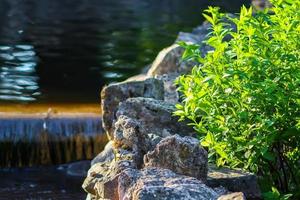 decoratieve kunstmatige waterval in zomerpark. foto