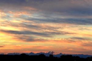 mooie oranje zonsondergang met wolken, natuurfoto achtergrond. reizen, vakantie, vakantie en ontspannen thema. overgangskleur. hemeltextuur, abstracte aardachtergrond foto