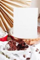 chocolademuffins in rode kopjes. mockup witboek copyspace. kleine geglazuurde keramische ramekin met bruine cakes op een grijze en witte achtergrond. foto
