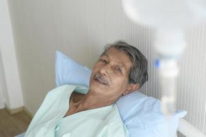 portret van senior patiënt liggend op bed in ziekenhuis, gezondheidszorg en medisch concept foto