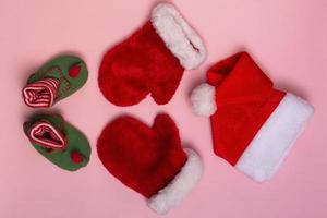 santa claus hoeden, wanten en sokken mockup op roze achtergrond. kerst platte mockup, close-up bovenaanzicht foto
