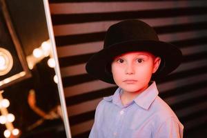 stijlvol portret van jonge jongen in zwarte hoed in fotostudio foto