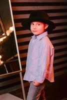 stijlvol portret van jonge jongen in zwarte hoed in fotostudio foto
