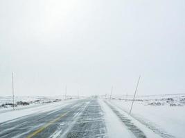 rijden door blizzard sneeuwstorm met ijzel op de weg, noorwegen. foto