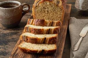 bananen brood. cake met banaan, traditionele amerikaanse keuken. sneetjes brood. donkere achtergrond foto