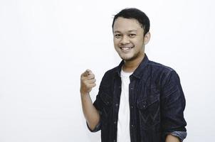jonge Aziatische man draagt groet handen. Indonesische man op grijze achtergrond. foto