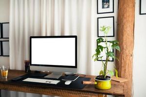 thuiskantoor, computerscherm op een houten tafel in huis foto