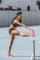 jonge en atletische vrouw training op atletiekbaan foto