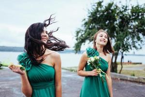 gelukkige jonge vrouwen op een bruiloft met boeketten bloemen foto