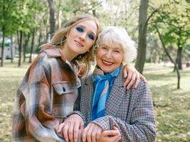 senior vrouw met jonge dochter wandelen buiten in het voorjaar. familie, generatie, zorg, liefde, vaccinatieconcept foto