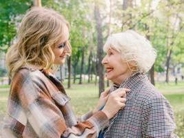 senior vrouw met jonge dochter wandelen buiten in het voorjaar. familie, generatie, zorg, liefde, vaccinatieconcept foto