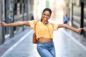 jonge zwarte vrouw danst in de zomer op straat. meisje dat alleen reist. foto