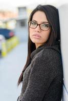 jonge vrouw met groene ogen en bril op stedelijke achtergrond foto