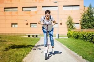 vrouw rijdt door de stad op een elektrische scooter foto