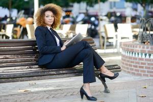 zwarte vrouw die tabletcomputer gebruikt in de stad foto