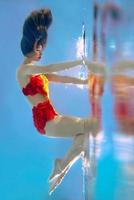 ongelooflijk, surrealistisch, ongelooflijk, geweldig onderwaterportret van slanke, fitte vrouw in fel oranje zwempak foto