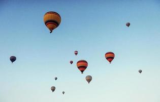 groep kleurrijke heteluchtballonnen tegen een blauwe lucht foto