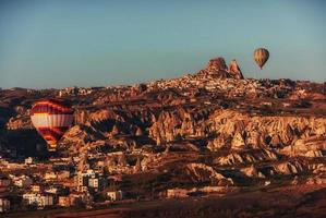 hete luchtballon die over rotslandschap in Cappadocia Turkije vliegt. foto