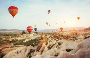 kleurrijke heteluchtballonnen die over rode vallei in cappadocië vliegen, foto