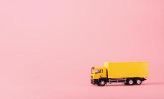 logistiek en bezorgservice - vrachtwagen en op roze achtergrond. winkelservice op het online web en biedt thuisbezorging. met kopie ruimte foto