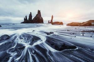 de rock troll tenen. reynisdrangar kliffen. zwart zandstrand. foto