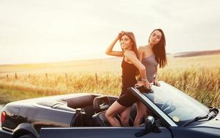 twee vrouwen in een zwarte auto op de berm foto