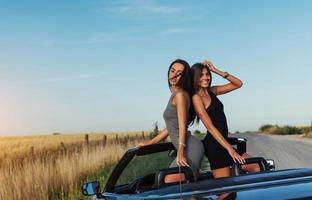 mooie twee vrouwen die in een cabrio zitten foto