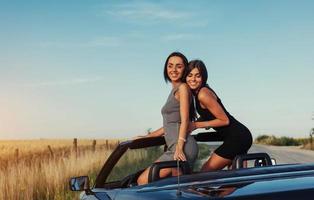 mooie twee vrouwen die in een cabrio zitten foto