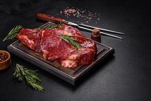 rauwe biologische gemarmerde biefstuk met kruiden op een houten snijplank foto