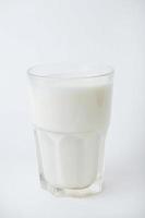 glas melk op witte achtergrond foto