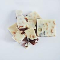 witte chocolade met noten, rozijnen op een achtergrond foto