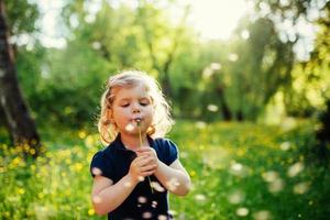 kind met paardenbloem foto