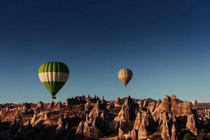 hete luchtballon die over rotslandschap in Cappadocia Turkije vliegt. foto