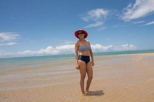 dame aan het strand staande op een zandbank bij eb in ponta do corumbau, brazil foto