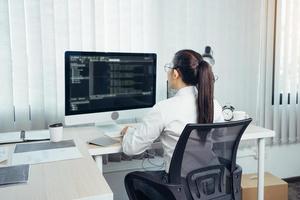 Aziatische vrouw professionele ontwikkeling programmering website werkt een software in kantoorruimte. foto
