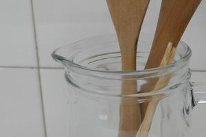 details van een glazen kan met houten kookgerei foto