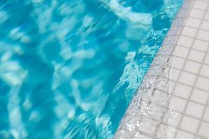 golvend wateroppervlak van het zwembad. blauw gescheurd water in zwembad zomervakantie banner, buiten ontspannen recreatieve leuke activiteit foto