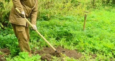 tuinman wiedt het bed voor het planten foto