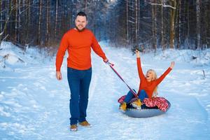 gelukkige jongen en meisje rijden in de sneeuw foto