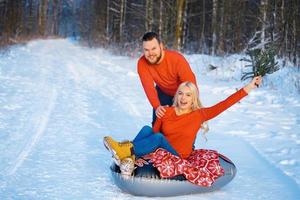 gelukkige jongen en meisje rijden in de sneeuw foto