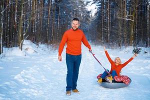 gelukkige jongen en meisje rijden in de sneeuw foto