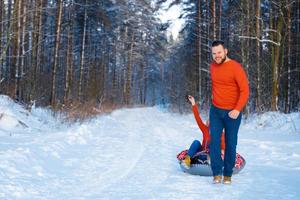 gelukkige jongen en meisje rijden in de sneeuw foto