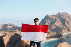 Indonesische man met Indonesische vlag op de top van het eiland Padar Labuan Bajo foto