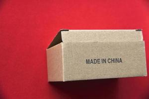 kartonnen doos met het opschrift made in china op een rode achtergrond foto