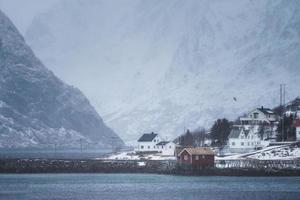 scandinavisch dorp in vallei aan kustlijn in sneeuwstorm bij lofoten foto