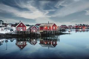 traditioneel rood houten huis aan de waterkant in vissersdorp in de winter in reine town, lofoten-eilanden foto